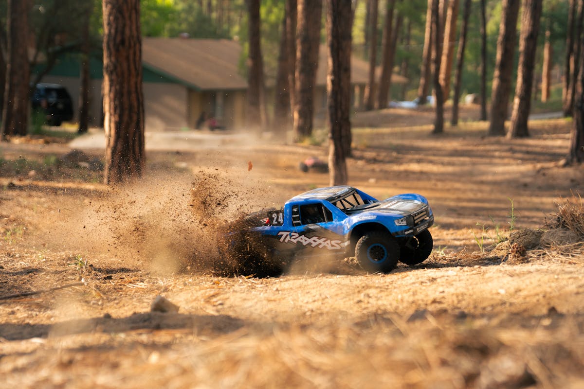 RC truck kicking up dirt on a forest trail